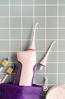 Munddusche, Zahnbürsten und Zahnpulver Draufsicht auf blauem Hintergrund foto