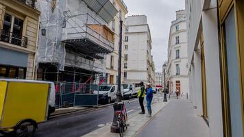 städtisch europäisch Straße Szene mit Gebäude unter Renovierung, Fußgänger, und geparkt Fahrzeuge auf ein wolkig Tag, geeignet zum Themen von Stadt Leben und Konstruktion foto
