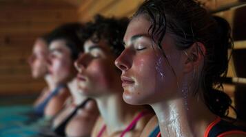 ein Nahansicht von ein Gruppe von erschöpft jung Sportler gespült Gesichter wie Sie entspannen im ein Sauna. foto