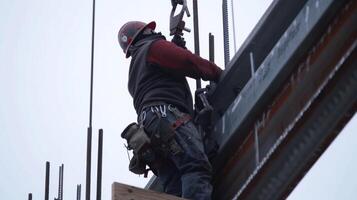 ein nah Schuss von ein Arbeiter Sicherung ein Stahl Strahl in Platz Hinzufügen zu das strukturell Integrität von das Himmelsser Ader foto