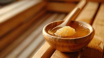 ein klein Schüssel von Honig und Zucker Sitzung auf ein Bank im das Sauna bereit zu Sein benutzt wie ein natürlich Gesicht schrubben. foto