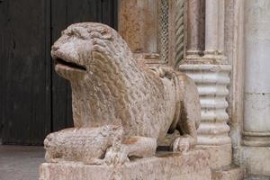 skulptur des löwen mit beten vor dem duomo in modena, italien foto