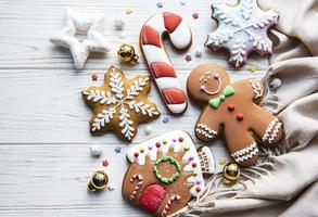 Weihnachtslebkuchen mit Weihnachtsschmuck auf weißem Holztisch foto