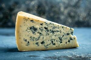 Keil von Roquefort Käse mit ein Fett gedruckt Blau zu schwarz Gradient Hintergrund, Hervorheben das heftig Blau Äderung von das Käse foto