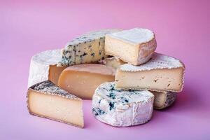 sortiert Käse Teller mit Blau Käse, Gouda, und Camembert auf ein lila zu Rosa Gradient Hintergrund, beschwingt und einladend foto