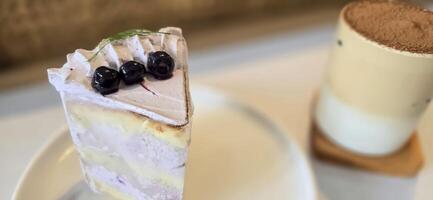 Scheibe von Blaubeere Kuchen dekoriert mit frisch Beeren auf Weiß Platte, köstlich geschichtet Kuchen, oben Aussicht foto