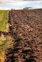 kultiviert Feld frisch gepflügt durch sonnig Tag foto