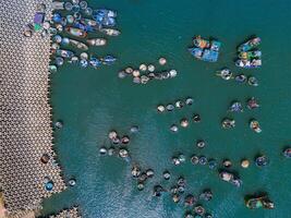 Antenne Aussicht von loc ein Angeln Dorf, vung tau Stadt. ein Angeln Hafen mit Tsunami Schutz Beton Blöcke. Stadtbild und traditionell Boote im das Meer. foto