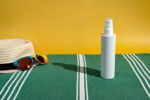 leer Sonnenschutz Flasche Sonne Hut und Sonnenbrille auf Strand Handtuch foto