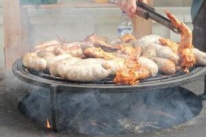 gebraten Würste und Hähnchen Flügel auf Grill Grill im das Dorf. braten Fleisch auf öffnen Feuer. Grill Party auf Hinterhof von Land Haus Kabine. Straße Essen Festival. Zuhause Kochen draussen. Picknick Zeit foto