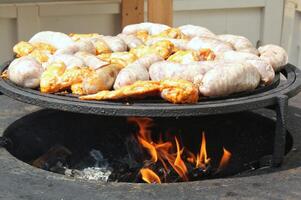 gebraten Würste und Hähnchen Flügel auf Grill Grill im das Dorf. braten Fleisch auf öffnen Feuer. Grill Party auf Hinterhof von Land Haus Kabine. Straße Essen Festival. Zuhause Kochen draussen. Picknick Zeit foto