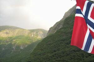 Aussicht von Geirangerfjord von das Boot mit norwegisch Flagge, Western Fjorde, Norwegen. skandinavisch Berge von sonniglvsfjorden Schlucht foto