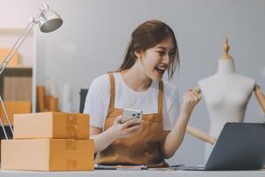 beginnend klein Geschäft Unternehmer sme freiberuflich, Porträt jung Frau Arbeiten beim Zuhause Büro, Kasten, Smartphone, Laptop, online, Marketing, Verpackung, Lieferung, b2b, klein, E-Commerce Konzept.. foto