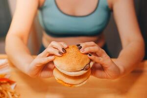 Saufgelage Essen Störung Konzept mit Frau Essen schnell Essen Burger, gefeuert Hähnchen , Donuts und Nachspeisen foto