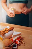 zu Essen oder nicht. freudlos rundlich Frau suchen beim das Burger während Denken zu Essen es oder nicht foto