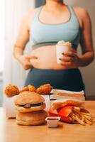 zu Essen oder nicht. freudlos rundlich Frau suchen beim das Burger während Denken zu Essen es oder nicht foto