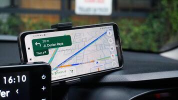 Anwendung,mit Google Karten auf ein Smartphone im ein Wagen. Semarang, 9 April 2024. foto