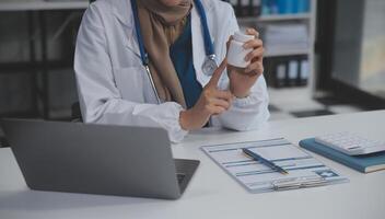 abgeschnitten Aussicht von Arzt im Weiß Mantel halten Flasche Medikament, verschreiben Tabletten zu krank geduldig über online Beratung. Familie Therapeut empfehlen Qualität Medikamente. Gesundheitspflege, Behandlung Konzept foto