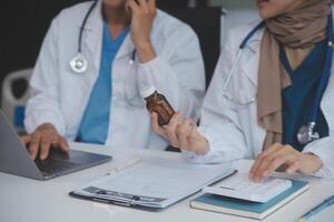 asiatisch Psychologe Frauen zeigen auf Tabletten Flasche zu erklären Medizin und Rezept zu weiblich geduldig während geben Beratung Über medizinisch und mental Gesundheit Therapie zu weiblich geduldig im Klinik. foto