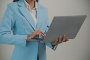 Porträt von ein glücklich asiatisch Geschäftsfrau Arbeiten auf Laptop Computer isoliert Über Weiß Hintergrund foto
