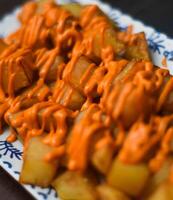 Portion von Spanisch Patatas bravas mit würzig Soße foto