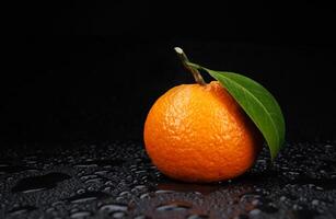 reif saftig Mandarine auf ein schwarz Hintergrund mit Wasser Tropfen. foto