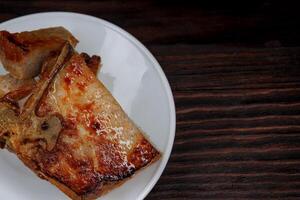 geröstet Schweinefleisch entrecote Schnitt in Stücke im ein Weiß Teller auf ein hölzern Schneiden Tafel . gegrillt Schweinefleisch Entrecôte. Schweinefleisch Steak. foto