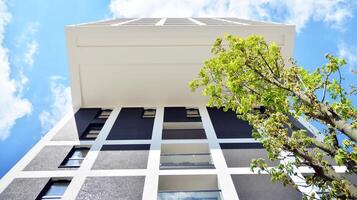 modern Wohnung Gebäude auf ein sonnig Tag mit ein Blau Himmel. Fassade von ein modern Wohnung Gebäude. Glas Oberfläche mit Sonnenlicht. foto