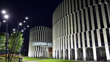 Muster von Büro Gebäude Fenster beleuchtet beim Nacht. Glas die Architektur , Unternehmen Gebäude beim Nacht - - Geschäft Konzept. foto