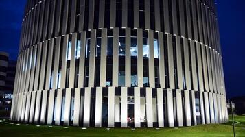 Muster von Büro Gebäude Fenster beleuchtet beim Nacht. Glas die Architektur , Unternehmen Gebäude beim Nacht - - Geschäft Konzept. foto