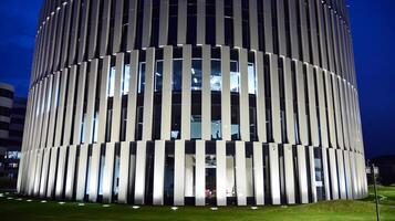 Muster von Büro Gebäude Fenster beleuchtet beim Nacht. Glas die Architektur , Unternehmen Gebäude beim Nacht - - Geschäft Konzept. foto