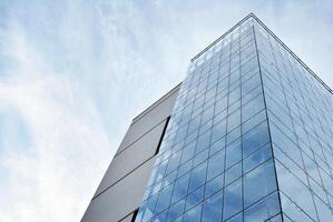 Glas Gebäude mit transparent Fassade von das Gebäude und Blau Himmel. strukturell Glas Mauer reflektieren Blau Himmel. abstrakt modern die Architektur Fragment. zeitgenössisch architektonisch Hintergrund. foto