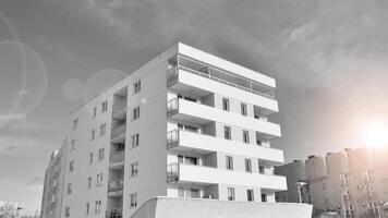 Fragment von das Gebäude Fassade mit Fenster und Balkone. modern Wohnung Gebäude auf ein sonnig Tag. Fassade von ein modern Wohn Gebäude. schwarz und Weiß. foto