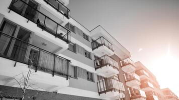 Fragment von das Gebäude Fassade mit Fenster und Balkone. modern Wohnung Gebäude auf ein sonnig Tag. Fassade von ein modern Wohn Gebäude. schwarz und Weiß. foto