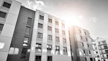 Fragment von das Gebäude Fassade mit Fenster und Balkone. modern Wohnung Gebäude auf ein sonnig Tag. Fassade von ein modern Wohn Gebäude. schwarz und Weiß. foto