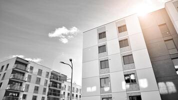 Fragment von das Gebäude Fassade mit Fenster und Balkone. modern Wohnung Gebäude auf ein sonnig Tag. Fassade von ein modern Wohn Gebäude. schwarz und Weiß. foto