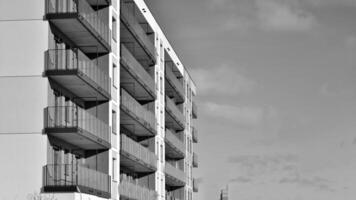 Fragment von das Gebäude Fassade mit Fenster und Balkone. modern Wohnung Gebäude auf ein sonnig Tag. Fassade von ein modern Wohn Gebäude. schwarz und Weiß. foto