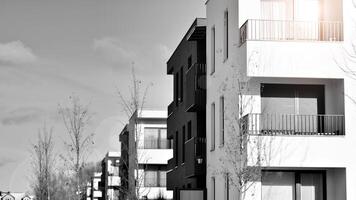 Fragment von das Gebäude Fassade mit Fenster und Balkone. modern Wohnung Gebäude auf ein sonnig Tag. Fassade von ein modern Wohn Gebäude. schwarz und Weiß. foto