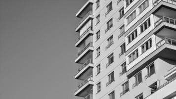 Fragment von das Gebäude Fassade mit Fenster und Balkone. modern Wohnung Gebäude auf ein sonnig Tag. Fassade von ein modern Wohn Gebäude. schwarz und Weiß. foto