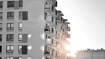 Fragment von das Gebäude Fassade mit Fenster und Balkone. modern Wohnung Gebäude auf ein sonnig Tag. Fassade von ein modern Wohn Gebäude. schwarz und Weiß. foto