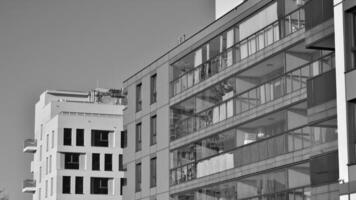 Fragment von das Gebäude Fassade mit Fenster und Balkone. modern Wohnung Gebäude auf ein sonnig Tag. Fassade von ein modern Wohn Gebäude. schwarz und Weiß. foto