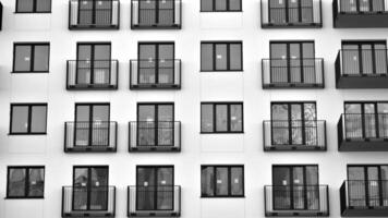 Fragment von das Gebäude Fassade mit Fenster und Balkone. modern Wohnung Gebäude auf ein sonnig Tag. Fassade von ein modern Wohn Gebäude. schwarz und Weiß. foto