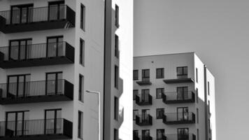 Fragment von das Gebäude Fassade mit Fenster und Balkone. modern Wohnung Gebäude auf ein sonnig Tag. Fassade von ein modern Wohn Gebäude. schwarz und Weiß. foto