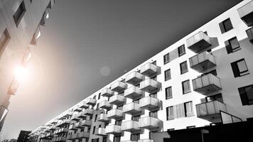 Fragment von das Gebäude Fassade mit Fenster und Balkone. modern Wohnung Gebäude auf ein sonnig Tag. Fassade von ein modern Wohn Gebäude. schwarz und Weiß. foto