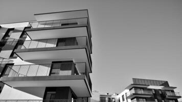 Fragment von das Gebäude Fassade mit Fenster und Balkone. modern Wohnung Gebäude auf ein sonnig Tag. Fassade von ein modern Wohn Gebäude. schwarz und Weiß. foto