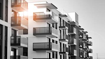 Fragment von das Gebäude Fassade mit Fenster und Balkone. modern Wohnung Gebäude auf ein sonnig Tag. Fassade von ein modern Wohn Gebäude. schwarz und Weiß. foto