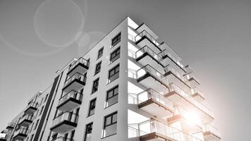 Fragment von ein Fassade von ein Gebäude mit Fenster und Balkone. modern Wohnung Gebäude auf ein sonnig Tag. Fassade von ein modern Wohnung Gebäude. schwarz und Weiß. foto