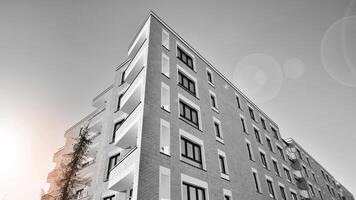 Fragment von ein Fassade von ein Gebäude mit Fenster und Balkone. modern Wohnung Gebäude auf ein sonnig Tag. Fassade von ein modern Wohnung Gebäude. schwarz und Weiß. foto