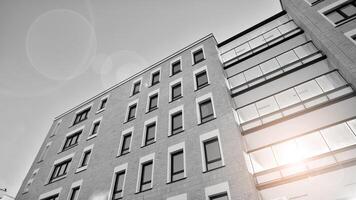 Fragment von ein Fassade von ein Gebäude mit Fenster und Balkone. modern Wohnung Gebäude auf ein sonnig Tag. Fassade von ein modern Wohnung Gebäude. schwarz und Weiß. foto