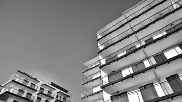 Fragment von ein Fassade von ein Gebäude mit Fenster und Balkone. modern Wohnung Gebäude auf ein sonnig Tag. Fassade von ein modern Wohnung Gebäude. schwarz und Weiß. foto